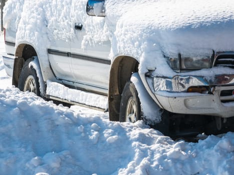 snow covered old white SUV car at sunny white winter day