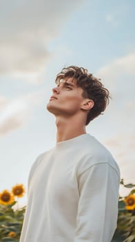 A thoughtful man stands in a sunflower field, contemplating the scenery and enjoying the serene atmosphere.
