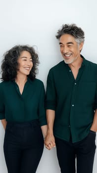 A joyful senior couple holding hands and smiling, expressing love and companionship against a light background.