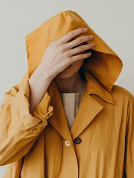 A mysterious figure in a yellow hood covers their face, creating an intriguing and enigmatic image.