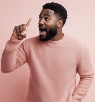Excited man pointing upwards with an expression of realization against a pink background.
