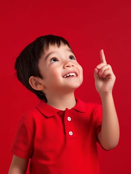 Joyful child in a red shirt pointing upwards, filled with curiosity and wonder, against a vibrant background.