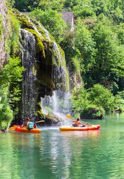 Canoes and waterfall of Saint-Chély-du-Tarn village in the valley of the Tarn river, french canyon