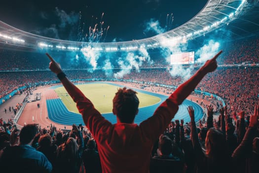 Fan celebrates with arms raised during a thrilling night match in a packed stadium, illuminated by fireworks and vibrant lights