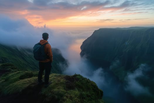 Hiker enjoying a stunning sunset view over a misty valley in ponta delgada, azores, portugal