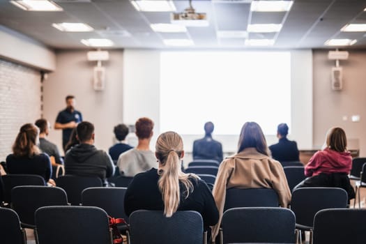 Speaker giving a talk in conference hall at business event. Rear view of unrecognizable people in audience at the conference hall. Business and entrepreneurship concept