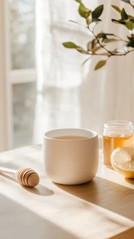 A cozy setup with a cup of tea, honey, and lemon in warm sunlight, ideal for a relaxing morning ritual.