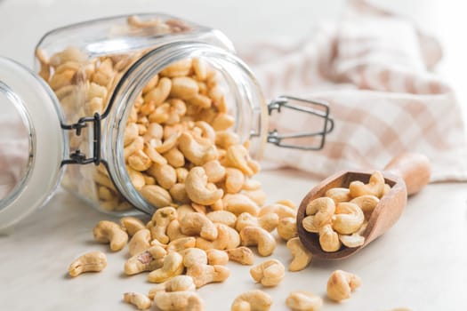 Roasted cashew nuts in jar on a kitchen table.