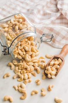 Roasted cashew nuts in jar on a kitchen table.