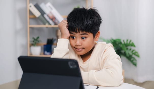 Educational of tech concept, Staying at home, Asian boy student using tablet learning. Presenting a modern educational way of life. Virtual internet online class from school teacher.