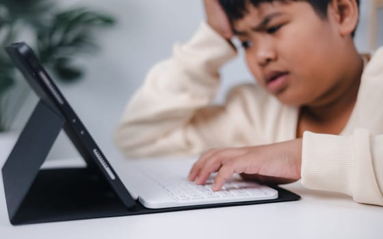 Boy using tablet for learning and stressed about online learning, Virtual internet online class from school teacher by remote meeting, Homeschooling and education concept, online education concept.