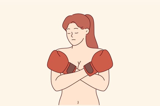 Woman suffering from domestic violence and male dominance covers bare chest with boxing gloves. Problem of domestic violence in different communities causes depression in feminist girl