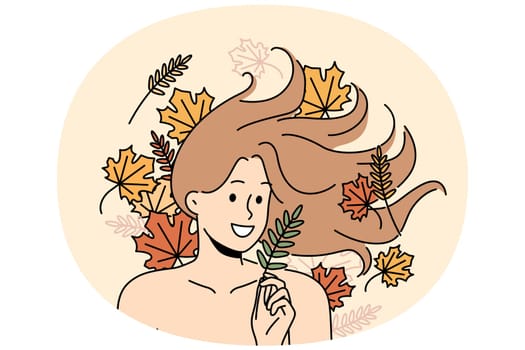 Woman with long flowing hair lies among autumn leaves and smiles rejoicing at onset of september. Woman with bare shoulders for advertising cosmetics or shampoo made on basis of herbs and plants