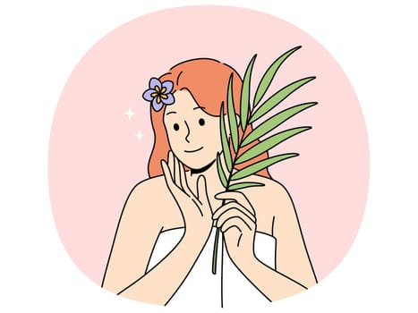 Woman with sprig of medicinal plant used for cosmetic purposes, stands in bath towel and rejoices at effect of using cream. Woman recommends using eco-masks and creams based on organic herbs