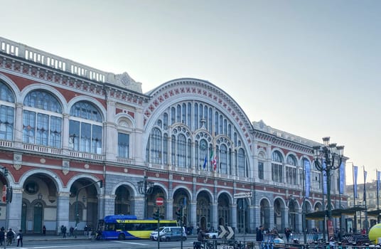 Turin, IT, Nov. 22, 2024  View of Porta Nuova railway station in Turin, a historic building with arched windows and flags.