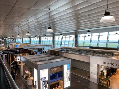 Turin, IT, Nov. 22, 2024  Interior view of Sandro Pertini Airport showing modern shops, large windows, and a spacious terminal design. Concept of travel and commercial spaces in airports.