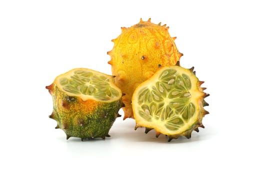Detailed image showcasing a vivid kiwano melon, also known as horned melon, with intricate textures of both whole and sliced parts.