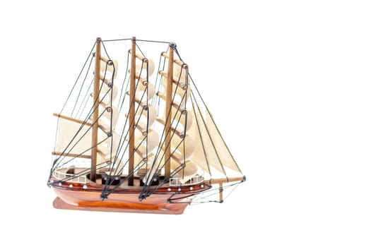 Detailed miniature of a classic sailing ship, showcasing intricate rigging and sails, set against a white background.