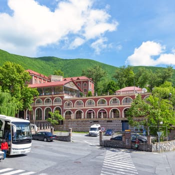 Shaki, Azerbaijan - May 15, 2024: Shaki Palace Hotel stands majestically, surrounded by lush greenery and hills. Visitors enjoy a serene atmosphere and stunning views from the hotel's terrace