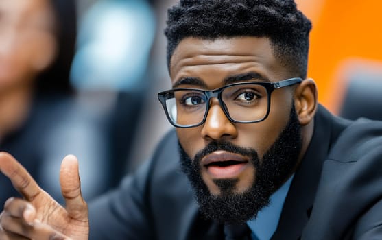Professional wearing glasses and suit gesturing during business conversation, closeup portrait with focused expression and modern corporate setting.