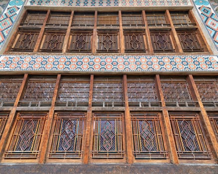 Shaki Khan's Palace features exquisite architectural details, including intricate wooden windows and vibrant tiles, exemplifying exceptional craftsmanship in the heart of Shaki, Azerbaijan
