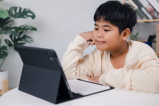 Asian boy student using tablet learning, Educational of tech concept, Staying at home, Presenting a modern educational way of life, Virtual internet online class from school teacher.
