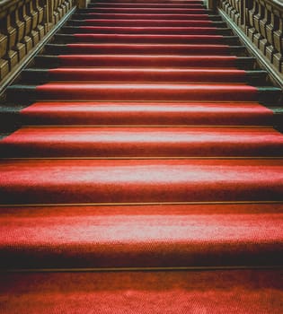 Vintage dark staircase with red carpet