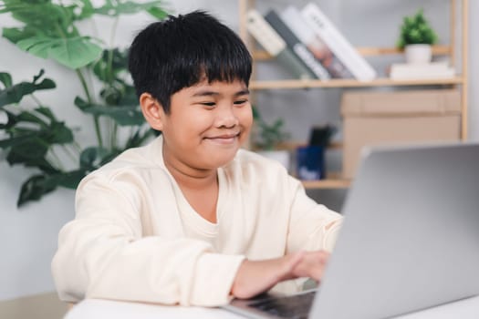 Educational of tech concept, Staying at home, Little Asian boy student using computer laptop learning, Presenting a modern educational way of life, Virtual internet online class from school teacher.