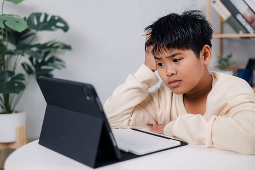 Asian boy student using tablet learning, Educational of tech concept, Staying at home, Presenting a modern educational way of life, Virtual internet online class from school teacher.