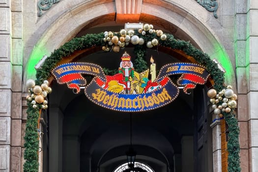 Munich, DE, Dec. 19 2022  Illuminated entrance sign to the Christmas Village - Weihnachtsdorf - in the courtyard of the Munich Residenz, decorated with garlands and ornaments