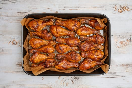 A tray filled with golden-brown roasted chicken drumsticks with crispy skin and delicious aroma. Perfectly cooked, this dish invites everyone to enjoy a tasty meal together.