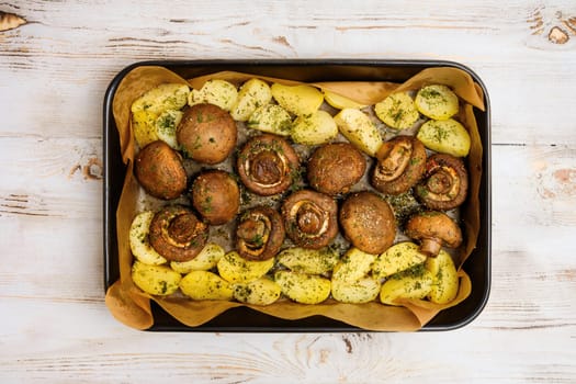 Champignon mushrooms and tender potatoes are seasoned with herbs and roasted to perfection on a baking tray, creating a delicious meal