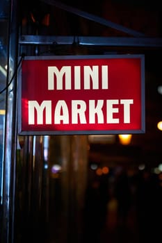 Illuminated advertisement for a mini market, late-night shop with extended opening hours in the old town of Prague in the Czech Republic at night