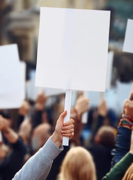 People holding banners during a protest parade on streets. Protesters demonstration with blank pancarts for copy space publicity. Multiple activists demand their rights during a rally