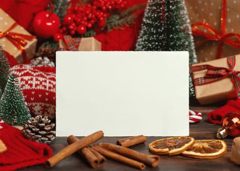 Horizontal greeting card near Christmas decor, trees, spices and red knitted sweater on dark wooden table closeup, place for text. Winter atmospheric mock up, family holiday time
