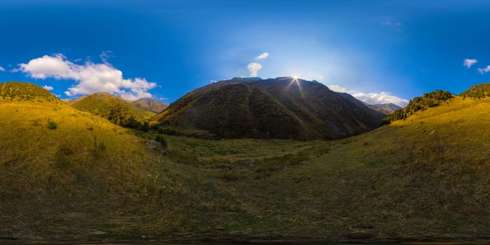 Full Spherical panorama of autumnal highland pasture in shadow of cliff in mountains at sunny afternoon in equirectangular projection