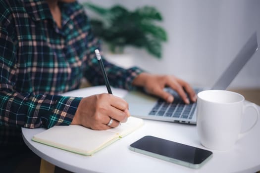 Close up shot hands of freelancer use laptop working on desk of her this is a lifestyle of freelance or editor. Asian woman working in home or small office with using a laptop.