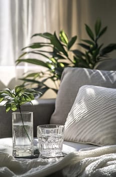 Relaxing indoor space features a light sofa with drinks and vibrant green plants, creating a serene atmosphere during the day.