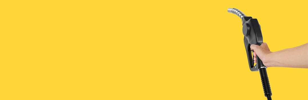 Hands holding Fuel nozzle on yellow background