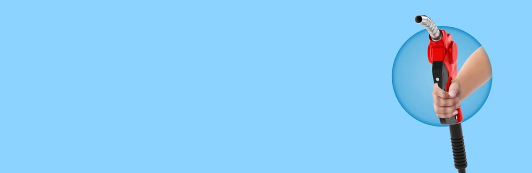 Hands holding Fuel nozzle on light blue  background