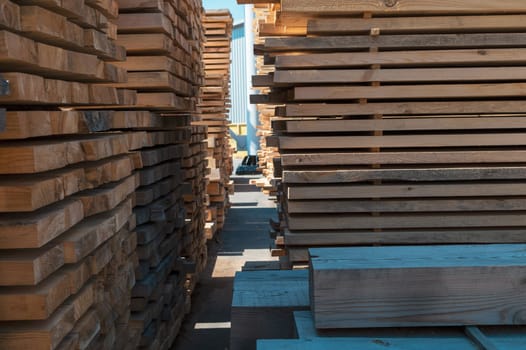 Stacked wooden planks close-up at lumber warehouse. Wood industry concept