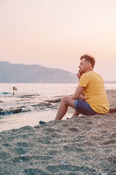 Man sits on the beach and looks at the sea in Alanya city, Turkey. Travelling or vacation concept