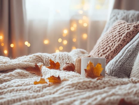 A cozy autumn scene with a warm drink on a blanket, surrounded by fallen leaves and soft pillows.