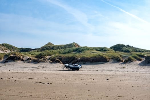 Sandy beach, dunes and a ship on dry land, on the North Sea coast in the Netherlands