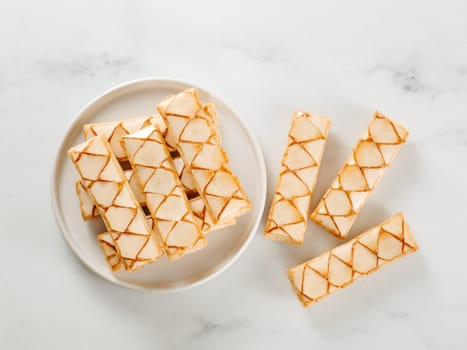 Italian crispy sweet bakery Sfogliatine glassate over white marble table surface. Tasty breakfast with apricot glaze puff pastries.