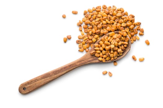 Roasted salted corn snack on wooden spoon isolated on a white background.