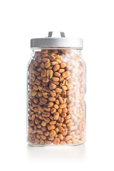 Roasted salted corn snack in jar isolated on a white background.