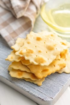 A crispy salted crackers on a white cutting board.