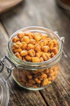 Roasted salted corn snack in jar on a wooden table.