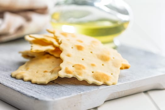A crispy salted crackers on a white cutting board.